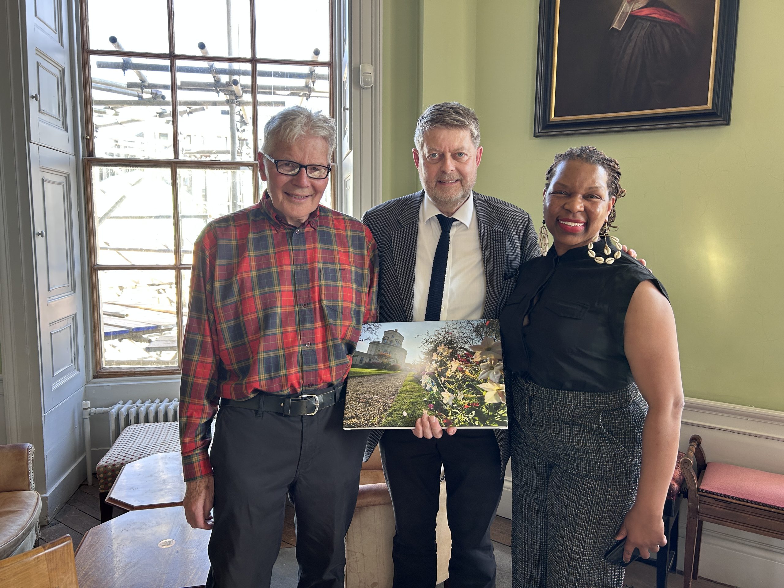Michael Pirie, Sir Michael Dixon and Student Cle Holly with picture presented to Michael Pirie by Cle. 