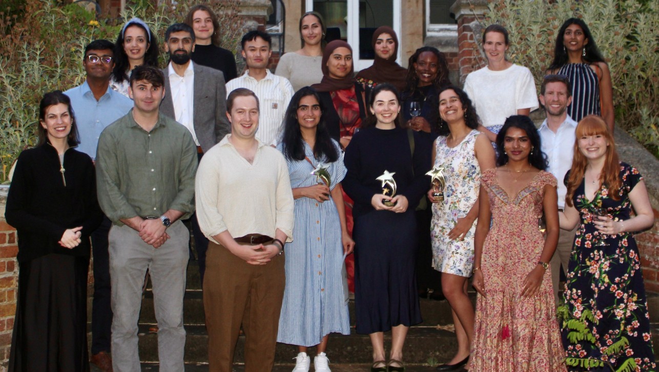 Group of people standing on stairs dressed for summer reception in garden