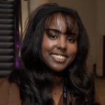 profile pic of young person smiling with escalator behind